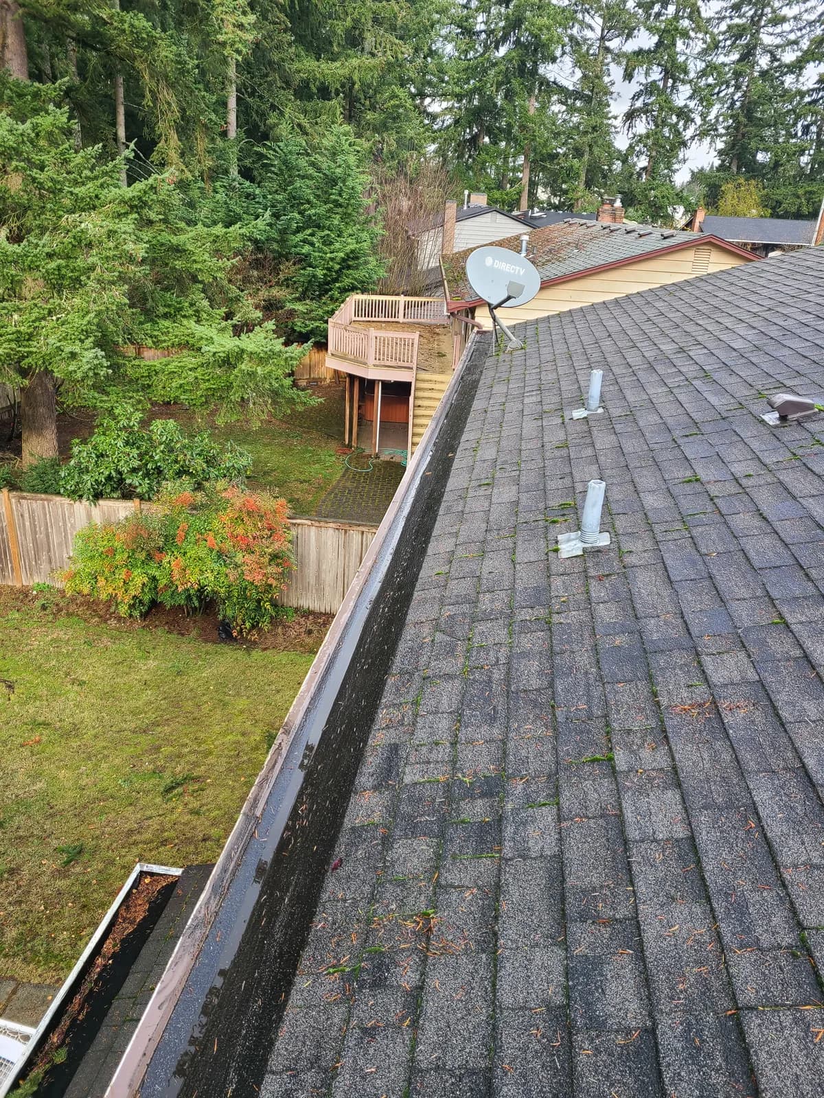 After — Debris-packed gutter corner cleared of buildup and rinsed to a clean channel
