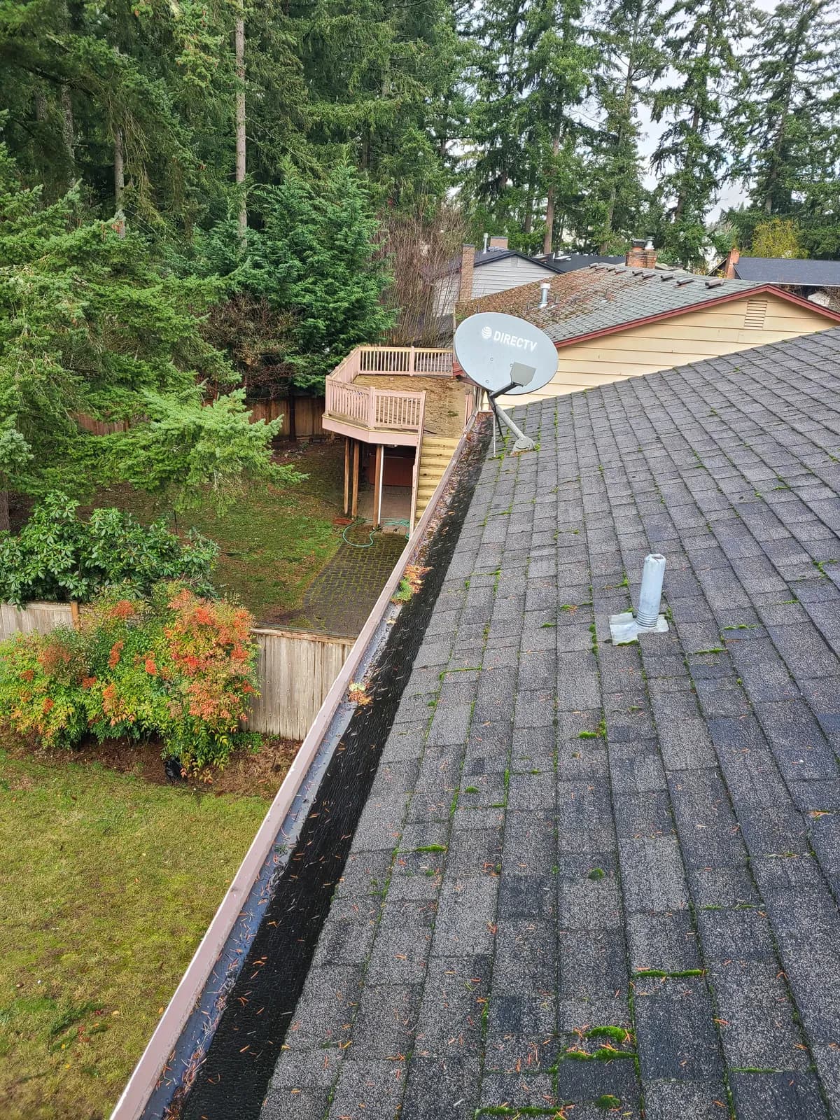 Before — Debris-packed gutter corner cleared of buildup and rinsed to a clean channel