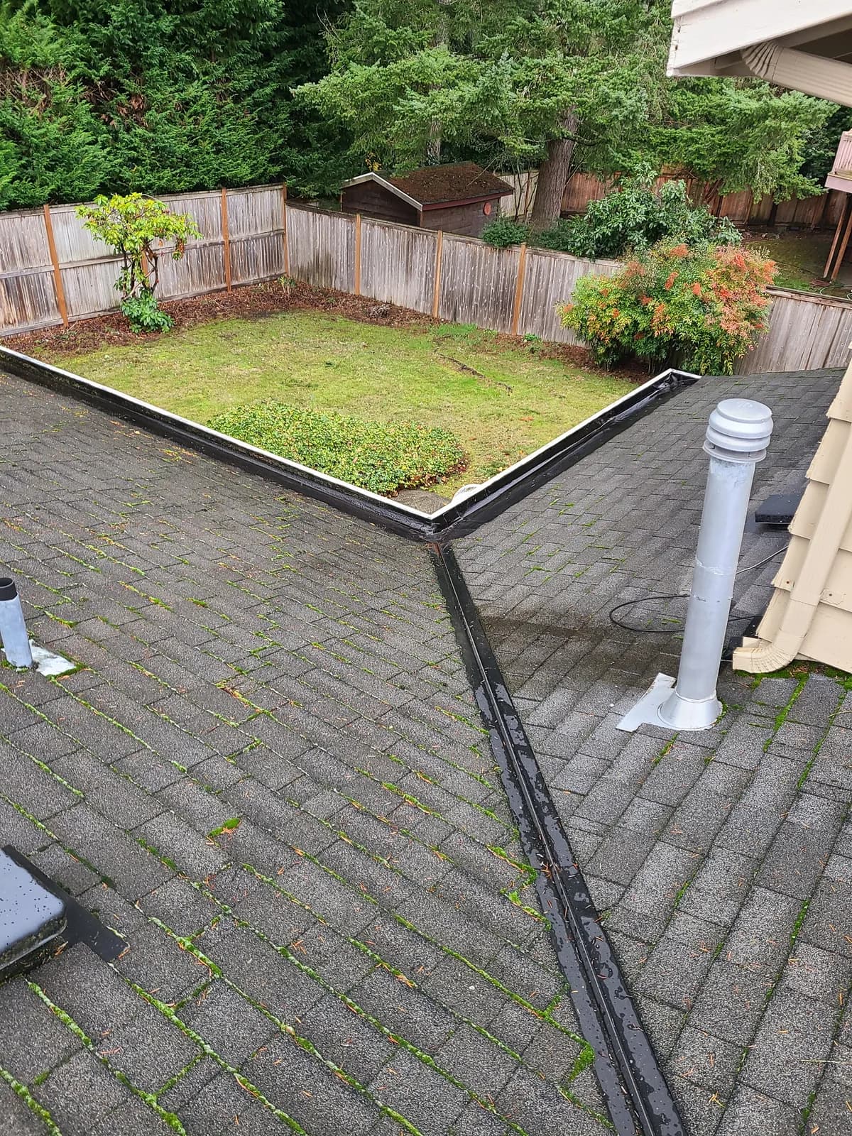 After — Leaf-clogged backyard gutter corner cleared to a clean channel